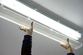 Hand installiert eine Philips LED-R&ouml;hre in eine Wannenleuchte